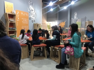 niños y niñas sentados en mesa didactica